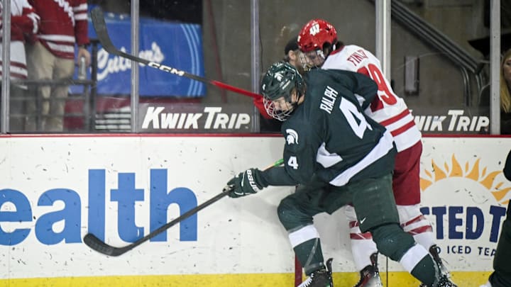 Michigan State defenseman Colin Ralph (4) and Wisconsin left wing Quinn Finley (19) collide along the boards in a game Thursday, January 15, 2026, at the Kohl Center in Madison, Wisconsin. Michigan State defenseman Colin Ralph (4) and Wisconsin left wing Quinn Finley (19) collide along the boards in a game Thursday, January 15, 2026, at the Kohl Center in Madison, Wisconsin.