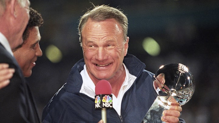 Dallas Cowboys head coach Barry Switzer holds the Lombardi trophy while talking to NBC sportscaster Greg Gumbel after a victory against the Pittsburgh Steelers in Super Bowl XXX 