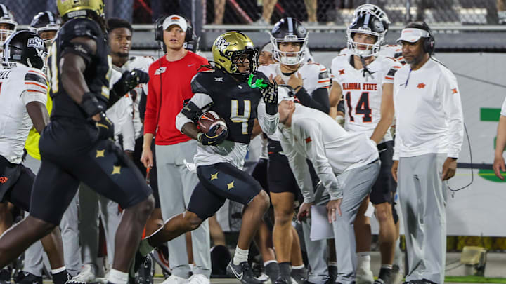 Nov 22, 2025; Orlando, Florida, USA; UCF Knights defensive back Braeden Marshall (4) intercepts a pass during the second half against the Oklahoma State Cowboys at Acrisure Bounce House. Mandatory Credit: Mike Watters-Imagn Images