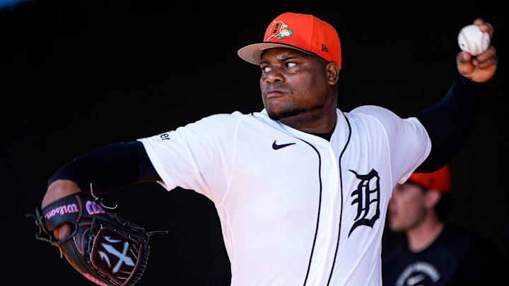 Valdez throws a baseball in a white Tigers unifor