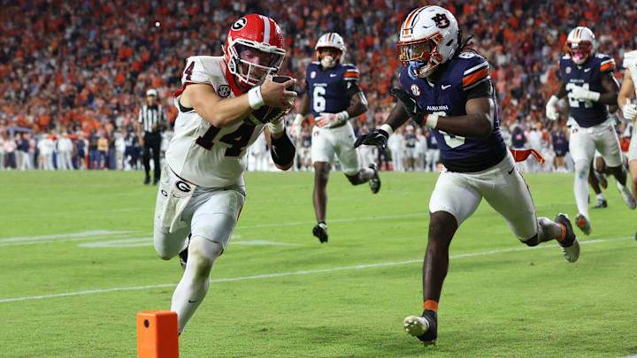 Oct 11, 2025; Auburn, Alabama, USA;  Georgia Bulldogs quarterback Gunner Stockton (14) gets past Auburn Tigers safety Kaleb Harris (8) and dives for the end zone during the fourth quarter at Jordan-Hare Stadium. Mandatory Credit: John Reed-Imagn Images
