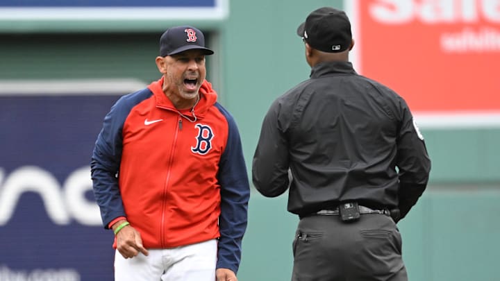 Sep 22, 2024; Boston, Massachusetts, USA;  Boston Red Sox manager Alex Cora (13) argues his case to umpire Alan Porter (64) during the first inning against the Minnesota Twins at Fenway Park. Mandatory Credit: Eric Canha-Imagn Images