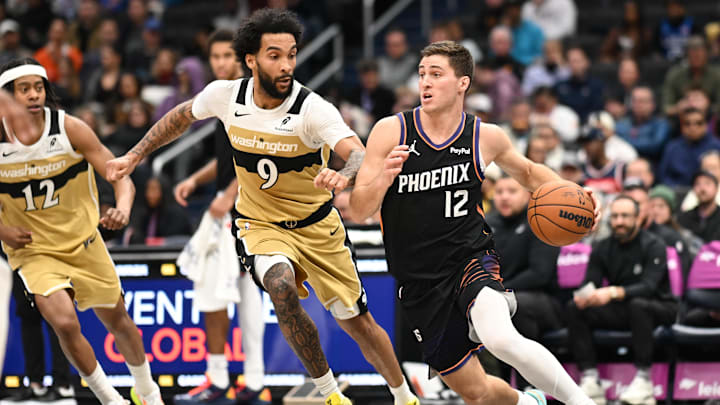 Dec 29, 2025; Washington, District of Columbia, USA;  Phoenix Suns guard Collin Gillespie (12) dribbles the ball in front of Washington Wizards forward Justin Champagnie (9) during the second quarter at Capital One Arena. Mandatory Credit: Rafael Suanes-Imagn Images
