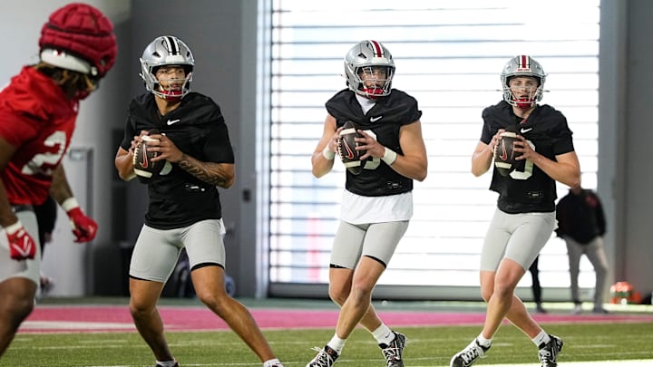 Ohio State Buckeyes quarterbacks, from right, Julian Sayin, Lincoln Kienholz and Tavien St. Clair take snaps during spring football practice at the Woody Hayes Athletic Center on March 17, 2025.