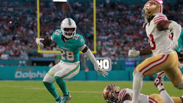 Miami Dolphins running back De'Von Achane (28) runs with the football past San Francisco 49ers linebacker Demetrius Flannigan-Fowles (45) during the second quarter at Hard Rock Stadium.