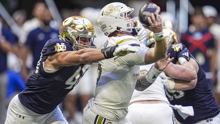 Oct 19, 2024; Atlanta, Georgia, USA; Georgia Tech Yellow Jackets quarterback Zach Pyron (5) is hit while throwing by Notre Dame Fighting Irish defensive end Joshua Burnham (40) at Mercedes-Benz Stadium. Mandatory Credit: Dale Zanine-Imagn Images