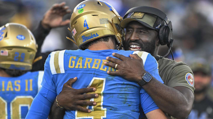 Nov 30, 2024; Pasadena, California, USA; UCLA Bruins head coach DeShaun Foster hugs quarterback Ethan Garbers (4) as time runs out during a Bruins victory over the Fresno State Bulldogs at Rose Bowl. Mandatory Credit: Robert Hanashiro-Imagn Images Nov 30, 2024; Pasadena, California, USA; UCLA Bruins head coach DeShaun Foster hugs quarterback Ethan Garbers (4) as time runs out during a Bruins victory over the Fresno State Bulldogs at Rose Bowl. Mandatory Credit: Robert Hanashiro-Imagn Images