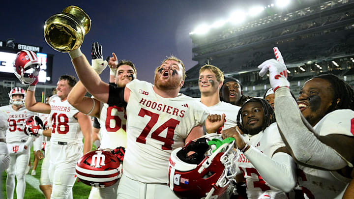 Indiana Hoosiers offensive lineman Bray Lynch (74) holds up The Old Brass Spittoon after beating Michigan State at Spartan Stadium.