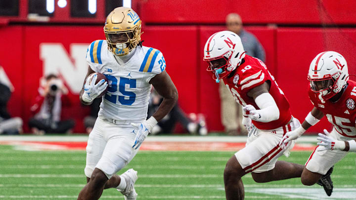 Nov 2, 2024; Lincoln, Nebraska, USA; UCLA Bruins running back T.J. Harden (25) runs the ball against Nebraska Cornhuskers defensive lineman Jimari Butler (10) during the third quarter at Memorial Stadium. 