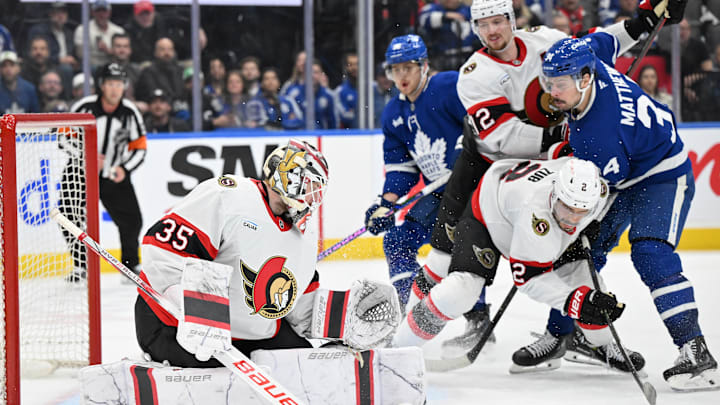 Mar 15, 2025; Toronto, Ontario, CAN;  Ottawa Senators goalie Linus Ullmark (35) makes a save as defensemen Artem Zub (2) and Thomas Chabot (72) hold back Toronto Maple Leafs forward Auston Matthews (34) in the third period at Scotiabank Arena. Mandatory Credit: Dan Hamilton-Imagn Images