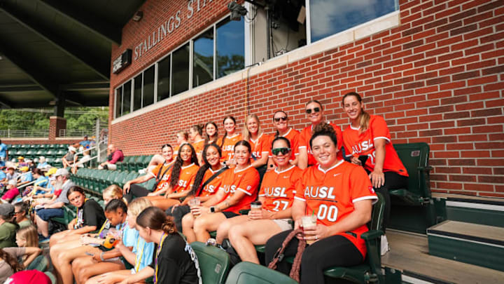 Athletes Unlimited Softball League players sit in the stands of the Little League Softball World Series games on Tuesday, August 5.