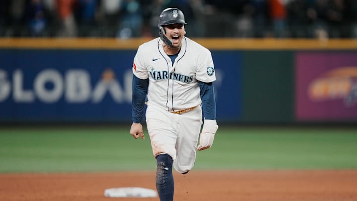Oct 17, 2025; Seattle, Washington, USA; Seattle Mariners first baseman Josh Naylor (12) reacts after third baseman Eugenio Suarez (not pictured) hits a grand slam against the Toronto Blue Jays in the eighth inning during game five of the ALCS round for the 2025 MLB playoffs at T-Mobile Park. Mandatory Credit: Stephen Brashear-Imagn Images