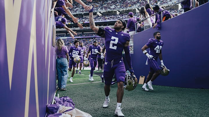Redshirt freshman cornerback Caleb Presley slaps hands with fans.