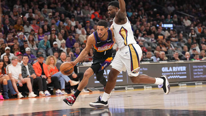 Mar 6, 2026; Phoenix, Arizona, USA; Phoenix Suns guard Devin Booker (1) drives against New Orleans Pelicans forward Zion Williamson (1) during the first half at Mortgage Matchup Center. Mandatory Credit: Joe Camporeale-Imagn Images
