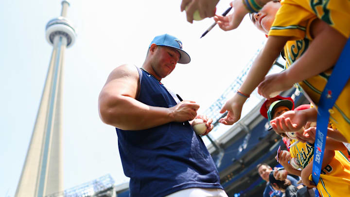 Ty France of the Toronto Blue Jays signs autographs for fans prior to Friday's game against the Kansas City Royals.