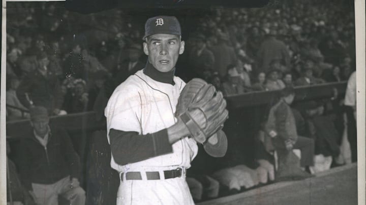 Former Detroit Tigers pitcher Hal Newhouser stands in white jersey and navy blue hat. Former Detroit Tigers pitcher Hal Newhouser stands in white jersey and navy blue hat.
