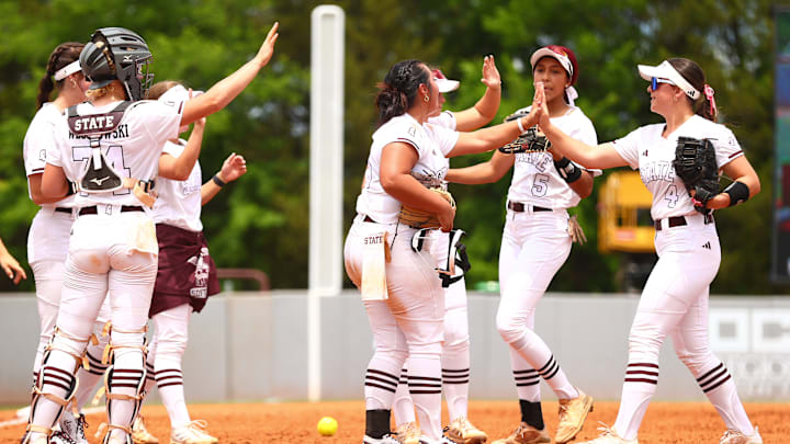 Mississippi State softball players high-five each other at the end of an inning during the 2024 season.