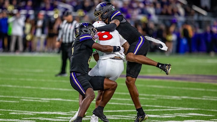Tacario Davis, right, brings down a Rutgers receiver with help.