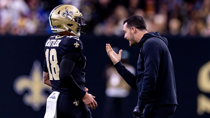 Dec 15, 2024; New Orleans, Louisiana, USA;  New Orleans Saints quarterback Derek Carr (4) jokes with quarterback Spencer Rattler (18) after a touchdown against the Washington Commanders during the second half at Caesars Superdome. Mandatory Credit: Stephen Lew-Imagn Images