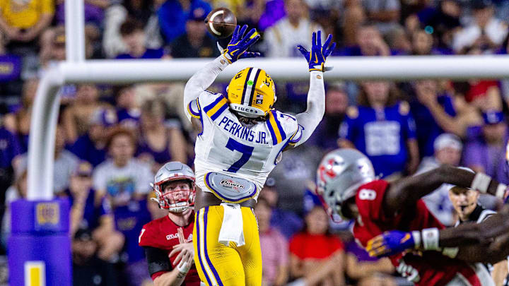 Sep 7, 2024; Baton Rouge, Louisiana, USA; Nicholls State Colonels quarterback Pat McQuaide (7) rolls out of the pocket against LSU Tigers linebacker Harold Perkins Jr. (7) during the second half at Tiger Stadium. Mandatory Credit: Stephen Lew-Imagn Images