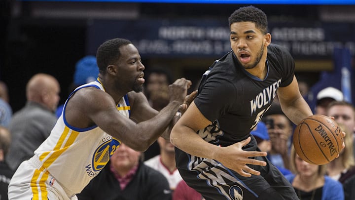 Mar 10, 2017; Minneapolis, MN, USA; Minnesota Timberwolves center Karl-Anthony Towns (32) controls the ball as Golden State Warriors forward Draymond Green (23) defends in the first quarter at Target Center. Mandatory Credit: Jesse Johnson-Imagn Images