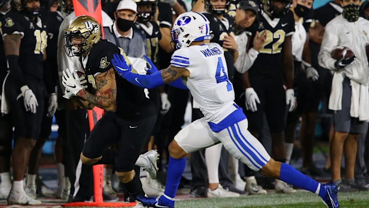 Dec 22, 2020; Boca Raton, Florida, USA; Brigham Young Cougars defensive back Troy Warner (4) shoves UCF Knights wide receiver Jacob Harris (87) out of bounds during the second half at FAU Stadium. Mandatory Credit: Jasen Vinlove-Imagn Images