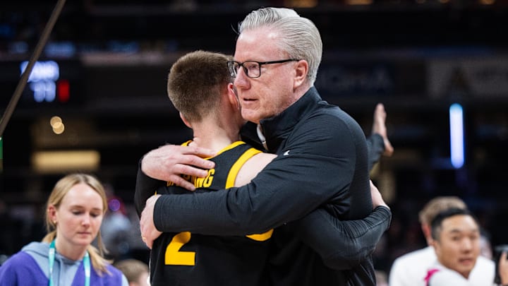 Iowa Hawkeyes head coach Fran McCaffery celebrates with guard Brock Harding (2) 