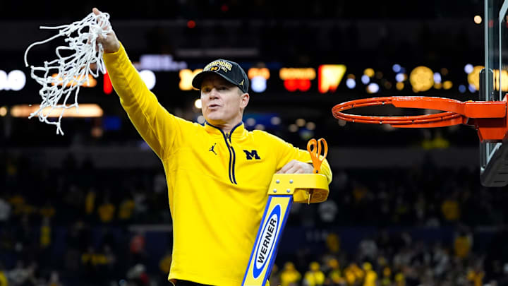 Michigan head coach Dusty May swings the net after winning the NCAA national championship.