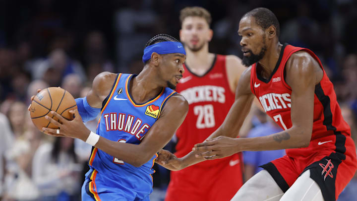 Oct 21, 2025; Oklahoma City, Oklahoma, USA; Oklahoma City Thunder guard Shai Gilgeous-Alexander (2) keeps the ball away from Houston Rockets forward Kevin Durant (7) during the second half at Paycom Center. Mandatory Credit: Alonzo Adams-Imagn Images