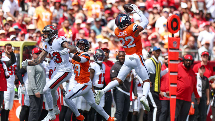 Sep 22, 2024; Tampa, Florida, USA; Denver Broncos safety Brandon Jones (22) intercepts the ball against the Tampa Bay Buccaneers in the first quarter  at Raymond James Stadium. 