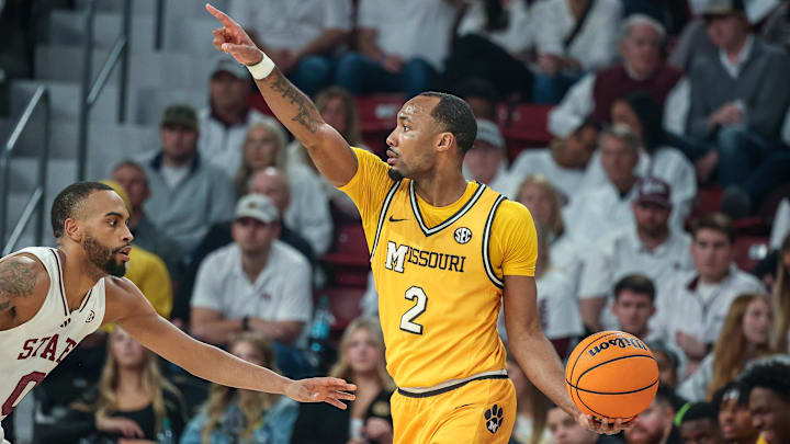 Feb 1, 2025; Starkville, Mississippi, USA; Missouri Tigers guard Tamar Bates (2) looks to pass the ball against Mississippi State Bulldogs guard Claudell Harris Jr. (0) during the second half at Humphrey Coliseum. Mandatory Credit: Wesley Hale-Imagn Images