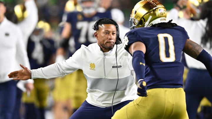 Oct 14, 2023; South Bend, Indiana, USA; Notre Dame Fighting Irish head coach Marcus Freeman celebrates with safety Xavier Watts (0) after Watts intercepted a pass in the first quarter against the USC Trojans at Notre Dame Stadium. Notre Dame won 48-20. Mandatory Credit: Matt Cashore-Imagn Images