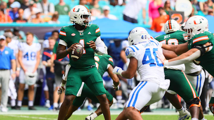 Nov 2, 2024; Miami Gardens, Florida, USA; Miami Hurricanes quarterback Cam Ward (1) looks for a passing option against the Duke Blue Devils during the second quarter at Hard Rock Stadium. Mandatory Credit: Sam Navarro-Imagn Images