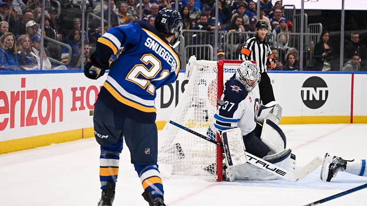 May 2, 2025; St. Louis, Missouri, USA; St. Louis Blues right wing Jimmy Snuggerud (21) is unable to score past Winnipeg Jets goaltender Connor Hellebuyck (37) during the second period in game six of the first round of the 2025 Stanley Cup Playoffs at Enterprise Center. Mandatory Credit: Connor Hamilton-Imagn Images