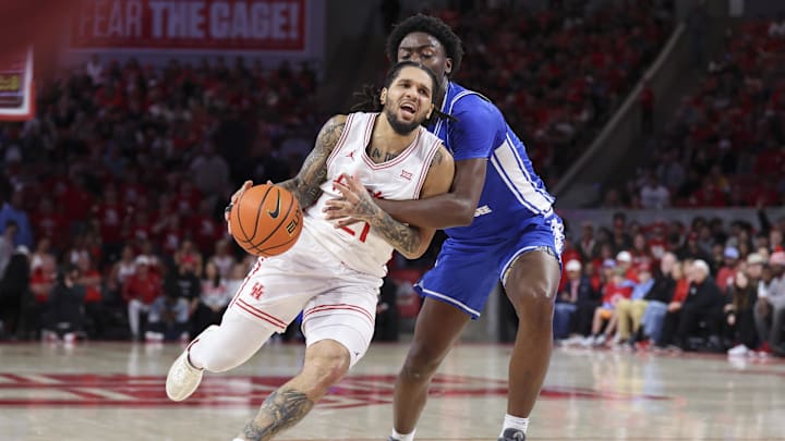 Dec 29, 2025; Houston, Texas, USA; Houston Cougars guard Emanuel Sharp (21) drives with the ball as Middle Tennessee Blue Raiders guard Kamari Lands (22) defends during the second half at Fertitta Center. Mandatory Credit: Troy Taormina-Imagn Images