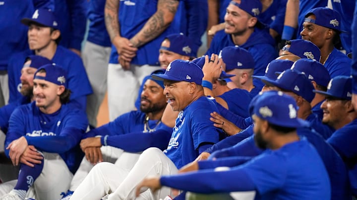 Los Angeles Dodgers manager Dave Roberts jumps into a team photo after the ninth inning of the MLB National League Wild Card Game 2 between the Los Angeles Dodgers and the Cincinnati Reds at Dodger Stadium in Los Angeles on Wednesday, Oct. 1, 2025. The Reds were eliminated from the postseason with an 8-4 loss to the reining World Series Champions La Dodgers.