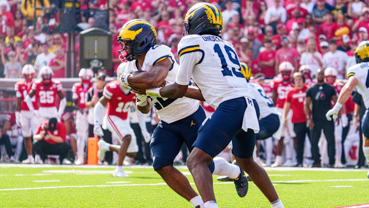 Sep 20, 2025; Lincoln, Nebraska, USA; Michigan Wolverines quarterback Bryce Underwood (19) hands the ball off to running back Justice Haynes (22) for a touchdown against the Nebraska Cornhuskers during the second quarter at Memorial Stadium. Mandatory Credit: Dylan Widger-Imagn Images
