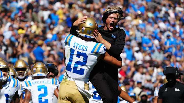Sep 24, 2022; Boulder, Colorado, USA; UCLA Bruins wide receiver coach Jerry Neuheisel and wide receiver Matt Sykes (12) celebrate a touchdown in the first quarter at Folsom Field. Mandatory Credit: Ron Chenoy-Imagn Images