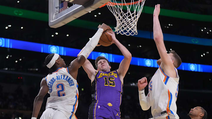 Nov 29, 2024; Los Angeles, California, USA; Los Angeles Lakers guard Austin Reaves (15) shoots the ball against Oklahoma City Thunder guard Shai Gilgeous-Alexander (2) and center Isaiah Hartenstein (55) in the first half at Crypto.com Arena. Mandatory Credit: Kirby Lee-Imagn Images