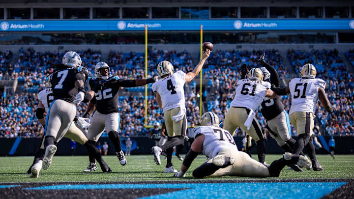 Nov 3, 2024; Charlotte, North Carolina, USA; New Orleans Saints quarterback Derek Carr (4) throws under pressure from Carolina Panthers defensive end Jonathan Harris (92) during the second quarter at Bank of America Stadium. Mandatory Credit: Scott Kinser-Imagn Images Nov 3, 2024; Charlotte, North Carolina, USA; New Orleans Saints quarterback Derek Carr (4) throws under pressure from Carolina Panthers defensive end Jonathan Harris (92) during the second quarter at Bank of America Stadium. Mandatory Credit: Scott Kinser-Imagn Images