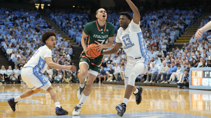 Feb 26, 2024; Chapel Hill, North Carolina, USA; Miami (Fl) Hurricanes guard Kyshawn George (7) with the ball as North Carolina Tar Heels guard Seth Trimble (7) and forward Jalen Washington (13) defend in the first half at Dean E. Smith Center. Mandatory Credit: Bob Donnan-USA TODAY Sports