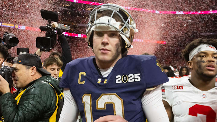 Jan 20, 2025; Atlanta, GA, USA; Confetti falls as Notre Dame Fighting Irish quarterback Riley Leonard (13) walks off the field after losing to the Ohio State Buckeyes in the CFP National Championship college football game at Mercedes-Benz Stadium. Mandatory Credit: Mark J. Rebilas-Imagn Images