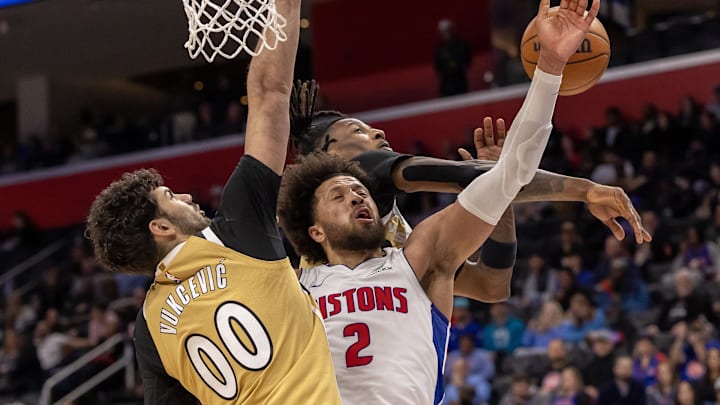 Feb 5, 2026; Detroit, Michigan, USA; Detroit Pistons guard Cade Cunningham (2) drives between Washington Wizards forward Tristan Vukcevic (00) as guard Jamir Watkins (5) blocks his shot during the second half at Little Caesars Arena. Mandatory Credit: David Reginek-Imagn Images