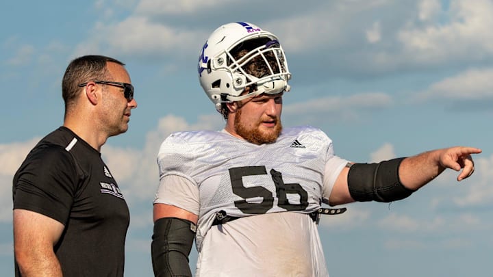 Holy Cross football coach Dan Curran and player Christo Kelly talk during practice at the school Tuesday.