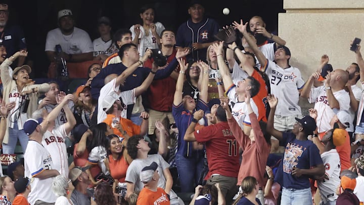 Jul 25, 2025; Houston, Texas, USA;  Fans attempt to catch a home run ball hit by Athletics designated hitter Nick Kurtz (not pictured) during the sixth inning against the Houston Astros at Daikin Park.