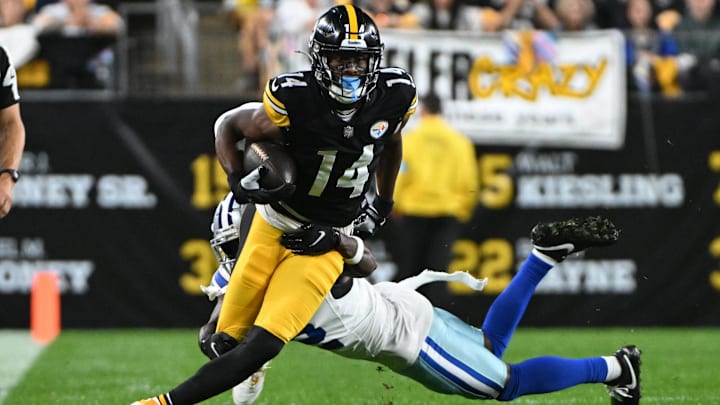 Oct 6, 2024; Pittsburgh, Pennsylvania, USA; Pittsburgh Steelers wide receiver George Pickens (14) breaks a tackle by Dallas Cowboys cornerback Jourdan Lewis (2) during the first quarter at Acrisure Stadium.