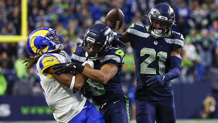 Nov 3, 2024; Seattle, Washington, USA; Seattle Seahawks cornerback Coby Bryant (8) breaks up a pass intended for Los Angeles Rams wide receiver Demarcus Robinson (15) during the fourth quarter at Lumen Field. Seattle Seahawks cornerback Devon Witherspoon (21) follows the play at right. Mandatory Credit: Joe Nicholson-Imagn Images