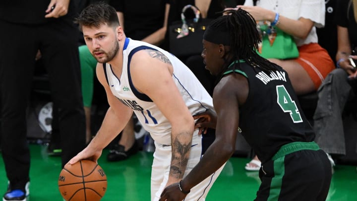 Jun 9, 2024; Boston, Massachusetts, USA; Dallas Mavericks guard Luka Doncic (77) dribbles the ball against Boston Celtics guard Jrue Holiday (4) during the first half of game two of the 2024 NBA Finals at TD Garden. Mandatory Credit: USA TODAY Sports Images