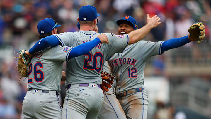 Sep 30, 2024; Atlanta, Georgia, USA; New York Mets second baseman Eddy Alvarez (26) and first baseman Pete Alonso (20) and shortstop Francisco Lindor (12) celebrate after a victory over the Atlanta Braves that clinched a wild card playoff birth at Truist Park. Mandatory Credit: Brett Davis-Imagn Images