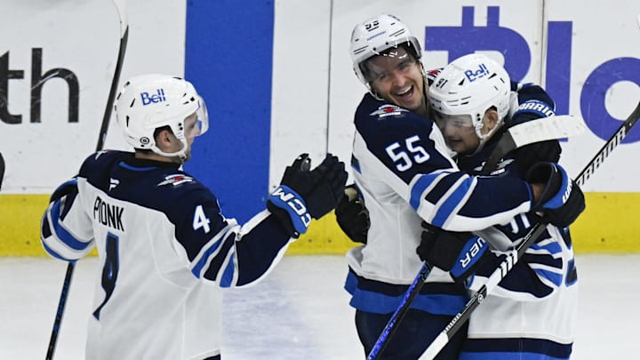 Apr 12, 2025; Chicago, Illinois, USA; Winnipeg Jets center Cole Perfetti (91) celebrates with center Mark Scheifele (55) and defenseman Neal Pionk (4) after he scores the game winning shootout goal against the Chicago Blackhawks during the overtime period at United Center. Mandatory Credit: Matt Marton-Imagn Images Apr 12, 2025; Chicago, Illinois, USA; Winnipeg Jets center Cole Perfetti (91) celebrates with center Mark Scheifele (55) and defenseman Neal Pionk (4) after he scores the game winning shootout goal against the Chicago Blackhawks during the overtime period at United Center. Mandatory Credit: Matt Marton-Imagn Images